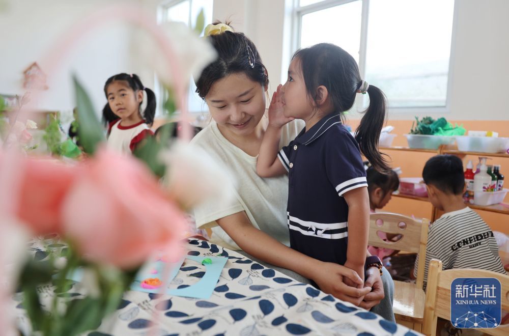 9月9日，在山东省临沂市沂南县铜井镇中心幼儿园，小朋友在跟老师分享节日祝福悄悄话。新华社发（王彦冰摄）