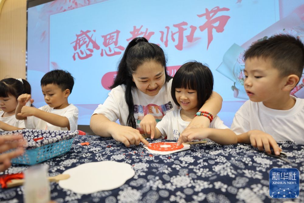 9月9日，河南省开封市新街口幼儿园的小朋友们跟老师一起制作剪纸团扇。新华社发（石斐摄）