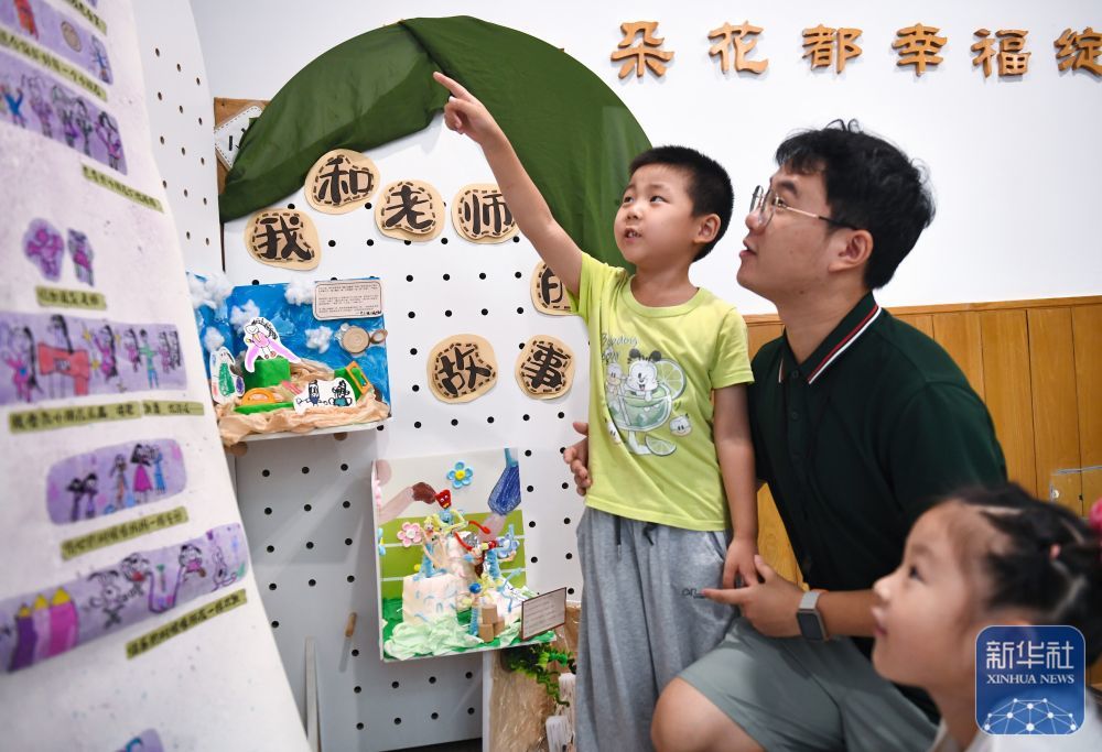 9月9日，在南京新世纪实验幼儿园，小朋友给老师讲述自己创作的“我和老师的故事”。新华社发（杨素平摄）