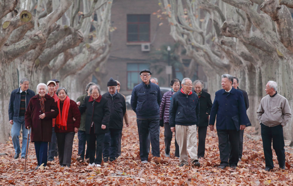 经历上世纪50年代交大西迁的师生行走在西安交大校园内（2015年11月19日摄）。新华社发