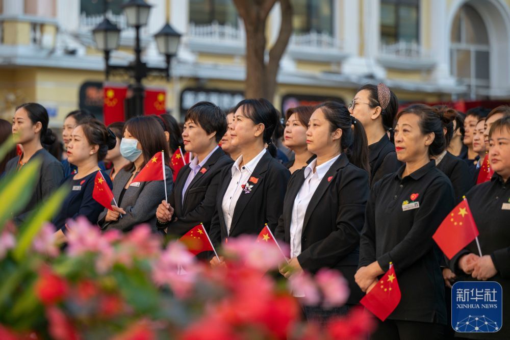 ↑ 10月1日，人们在哈尔滨市道里区中央大街参加升旗仪式。新华社记者 张涛 摄