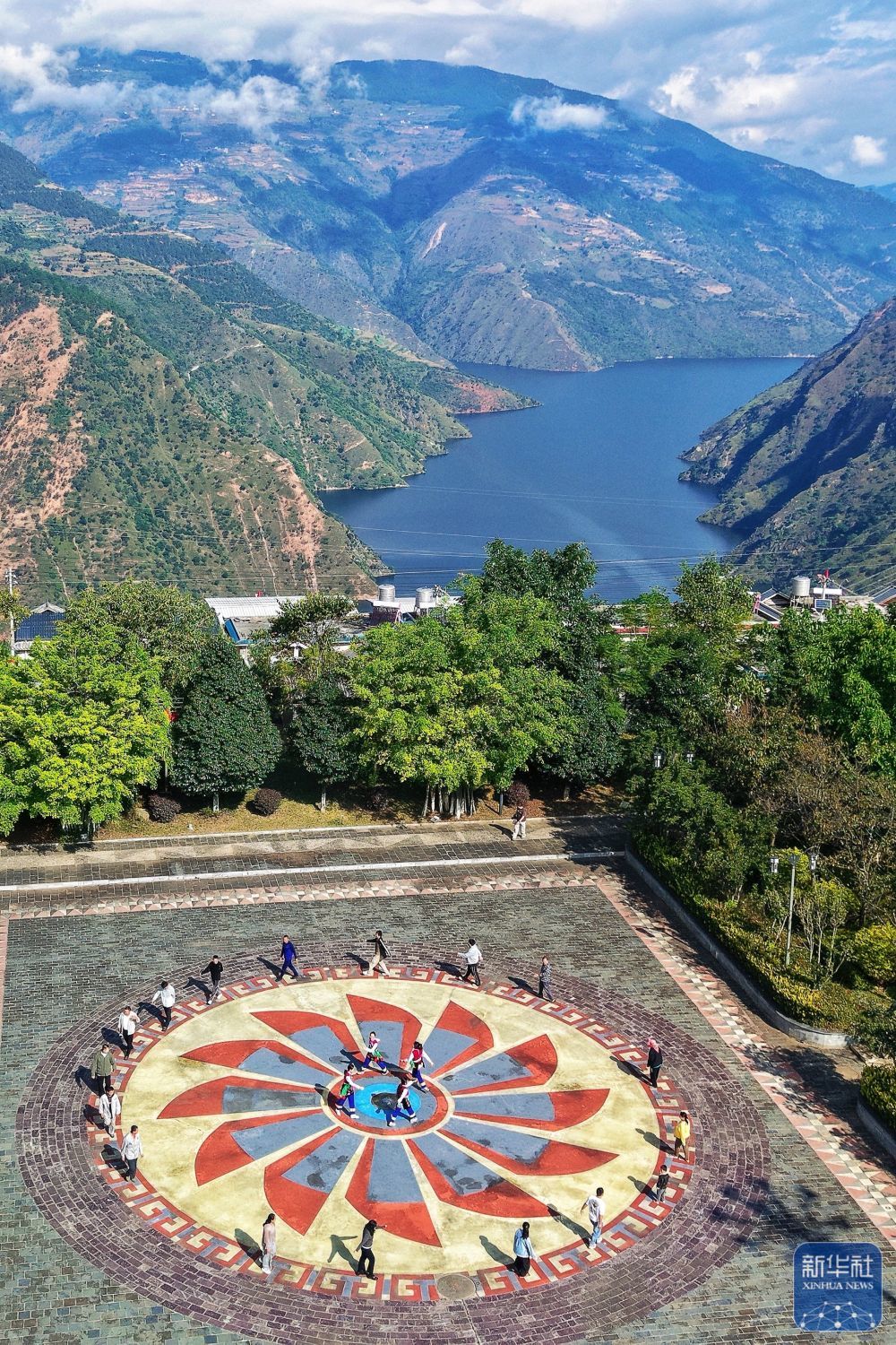 ↑ 10月31日，小湾东镇居民在澜沧江畔的移民广场休闲（无人机照片）。