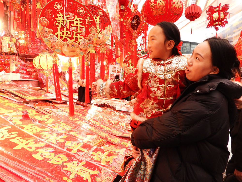 ↑ 2月15日，市民在四川省达州市通川区珠市街年货大集选购春节饰品。新华社发（邓良奎 摄）