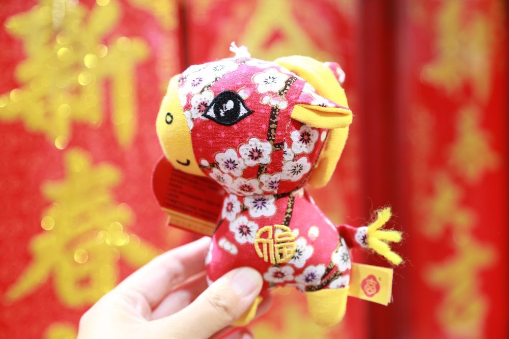 ↑ 2月15日，人们在云南省蒙自市一商场展示选购的马造型饰品。新华社发（薛莹莹摄）