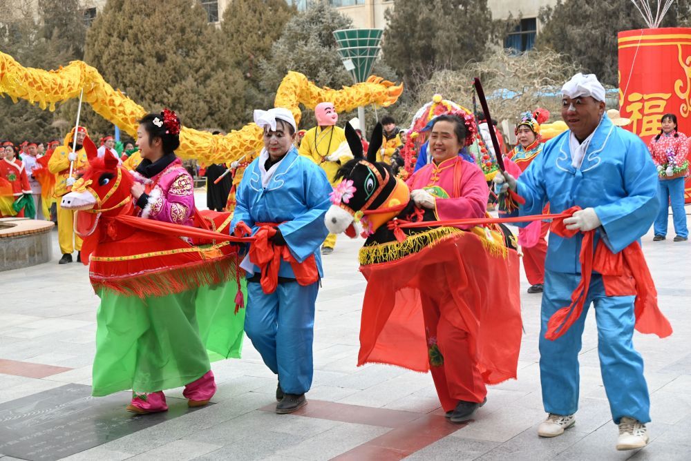 ↑ 2月15日，一支社火队在甘肃省敦煌市城区市政广场表演社火跑驴。新华社发（张晓亮摄）