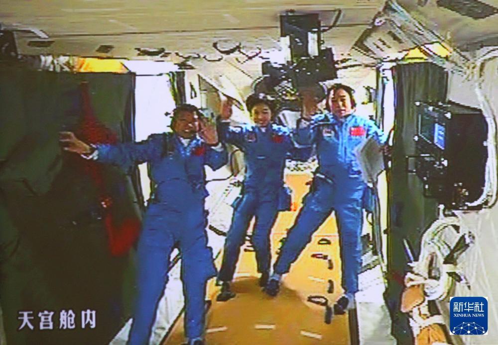 2012年6月18日，北京航天飞控中心大屏幕显示航天员景海鹏、刘洋、刘旺（从右至左）在天宫一号实验舱内。新华社记者 查春明 摄