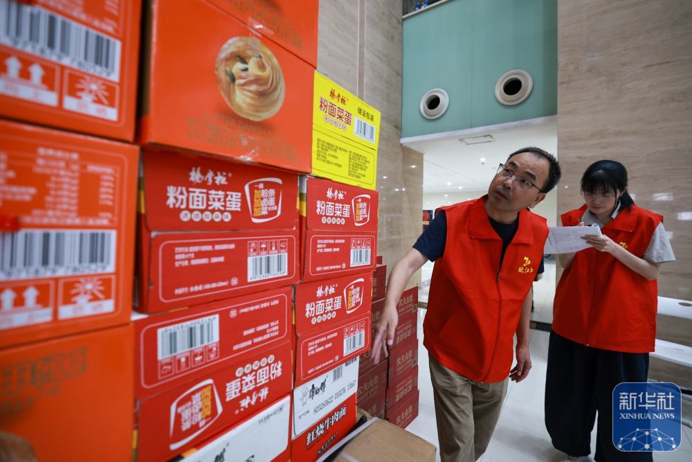 ↑ 7月11日，志愿者在浙江省乐清市城东街道安置点内清点储存物资数量。新华社记者 江汉 摄