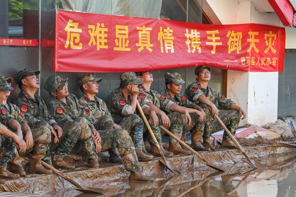 ↑ 7月10日，在广西贵港市，从外地前来支援的救灾人员在清淤间隙就地休息。