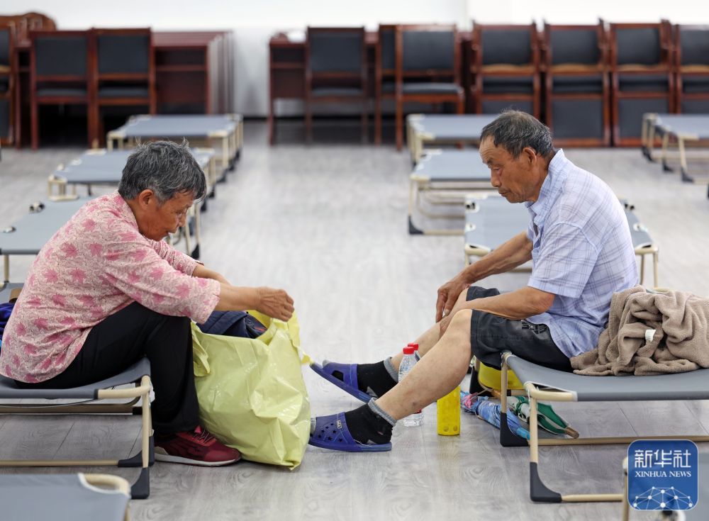 ↑ 7月11日，在上海市金山区石化街道的防汛安置点，一对老年夫妇在整理随身物品。受台风“巴威”外围环流影响，上海将迎来大风降雨天气，全市已全面启动防汛防台风应急处置工作。新华社记者 刘颖 摄