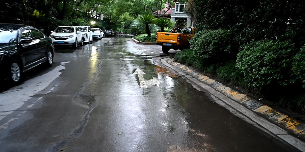 清洁人员正用水清洗小区道路。 澎湃新闻记者 张呈君 图