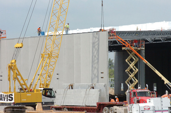 Crane lifts a section of wall into place.