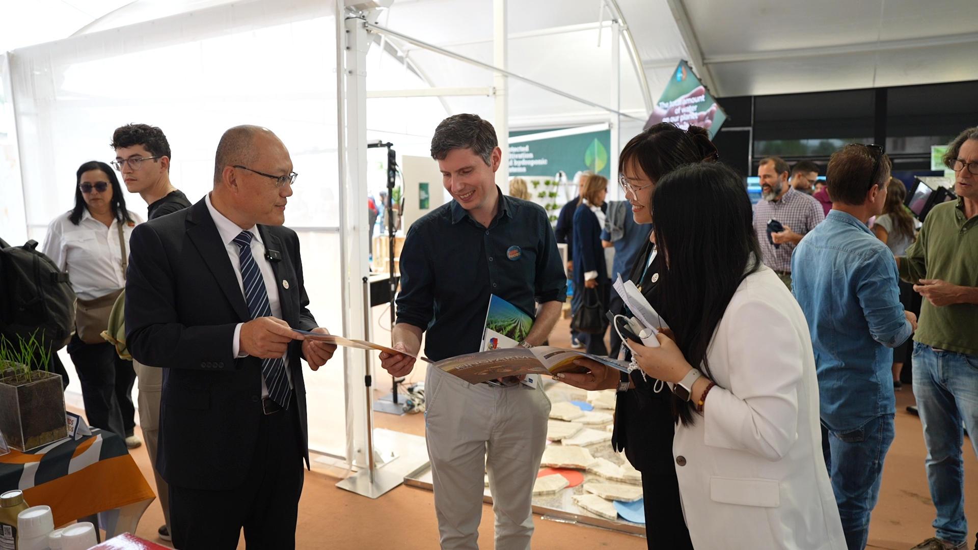 1426084017667522.jpg 3.曹磊及相关工作人员与参展人员交流.jpg